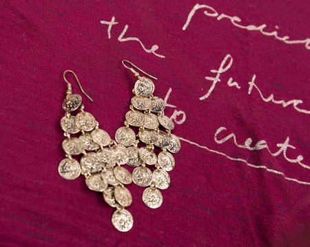Gold earrings on red backgroundの写真素材
