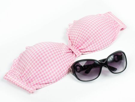 Pink bikini top with sunglasses isolated on whiteの写真素材