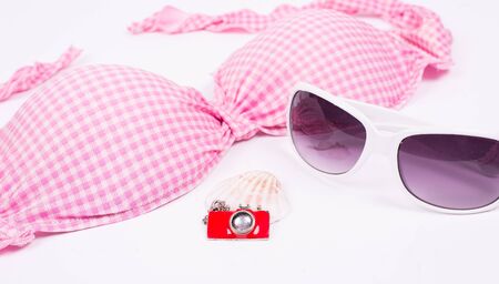 Bikini top with sunglasses and photo camera isolatedの写真素材