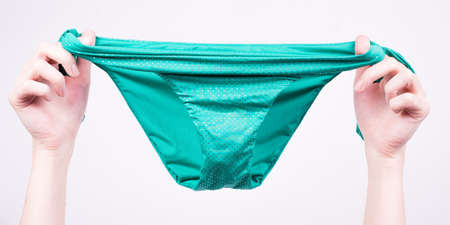 Woman holding a bikini bottom with white backgroundの写真素材