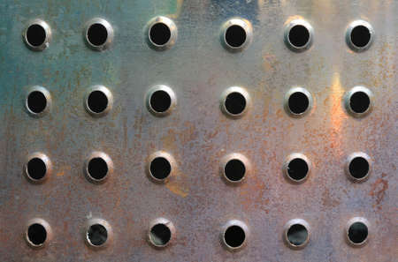 Metal background with holes. Close up photoの写真素材