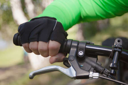 A gloved hand holds the handlebars firmly.の写真素材