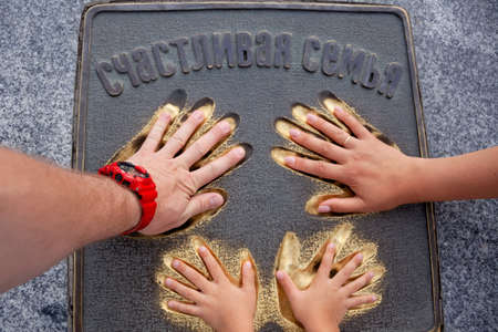 Dad, mom and baby. Close-up of a handの写真素材