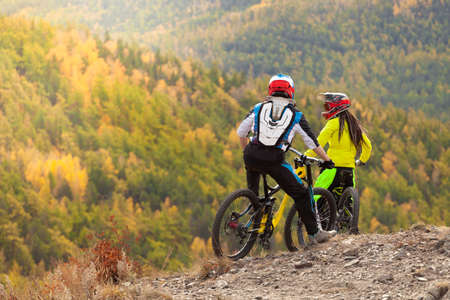 cyclists enjoy the autumn forest landscape at the top of the mountainの写真素材
