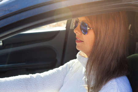 The girl at the wheel is drinking alcohol. Traffic safety threatの写真素材