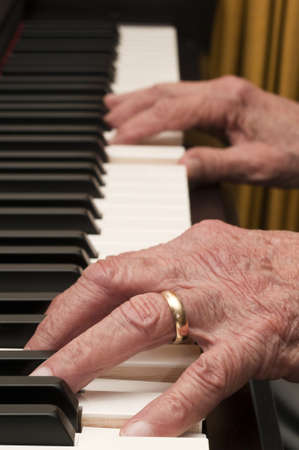 Selective focus on old hands playing the piano の写真素材