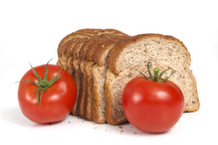 Fresh tomatoes in  front of healthy twelve grain bread islolated on white backgroundの写真素材