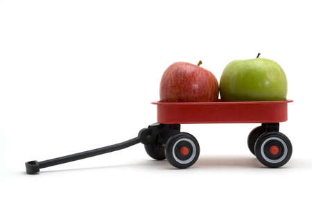 Green and red apple in a small red wagon.の写真素材