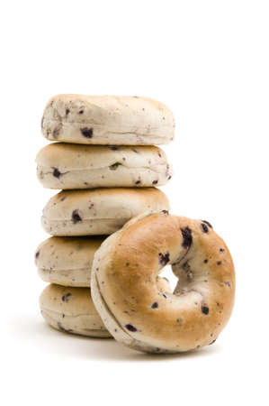 One blueberry bagel resting on a stack of bagels all isolated on white backgroundの写真素材