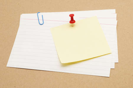 Pushpin holding a sticky note on index cards