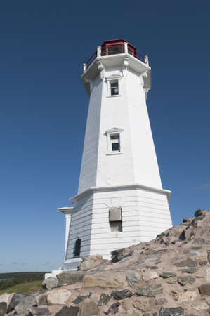 Louisbourg lighthouse with stone support in the foreground - intense blue sky good for copy spaceの写真素材