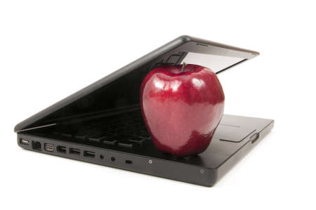 Computer closing on a red apple, isolated on a white background