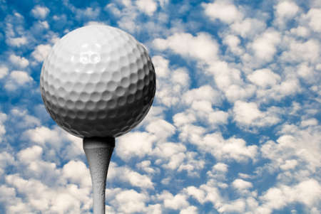 Golfer looks up to the heavens wishing for a hole in one with Golf Ball on the tee in the foregroundの写真素材