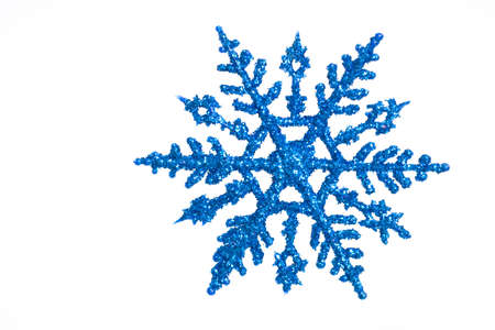 Blue snowflake ornament with sparkles on a white backgroundの写真素材