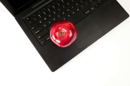 Looking down an apple resting on the laptop keyboardの写真素材