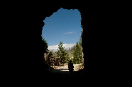 Woman walks out through the tunnel opening on the Myra Canyon Hikeの写真素材