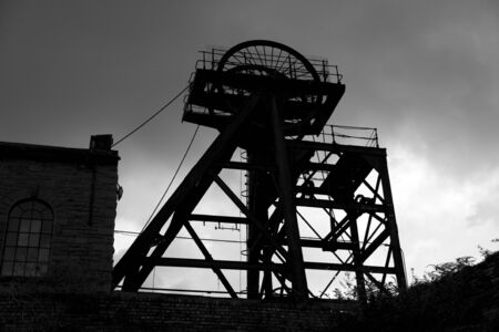 Old abandoned Welsh Coal Mine Pit Gear Silhouette, stormy skyの写真素材
