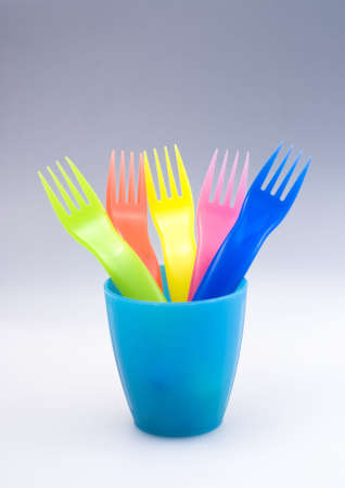 Bright colored plastic forks in cupの写真素材