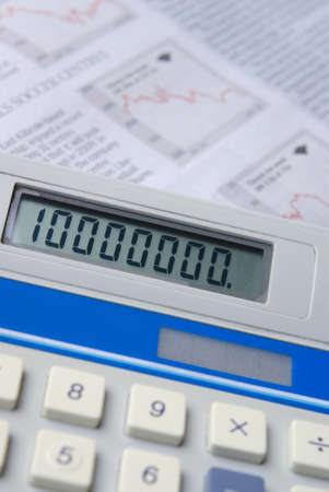 Calculator with financial newspaper in background. Selective focus.