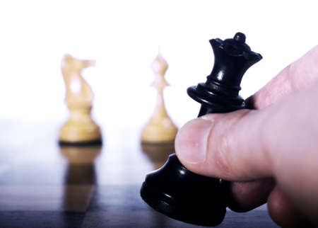Chess piece moved by hand on a chessboard as a business conceptの写真素材