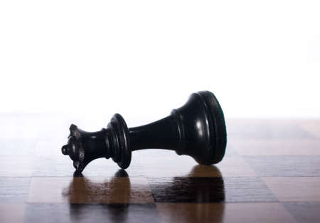 Chess piece on side on a chessboard as a business conceptの写真素材