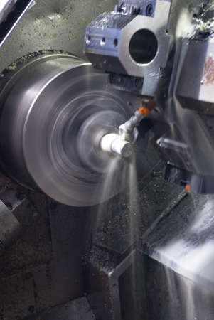 Long exposure of CNC lathe with cooling fluid on machined partの写真素材