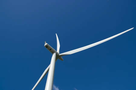 Modern wind turbine detail with deep blue sky.