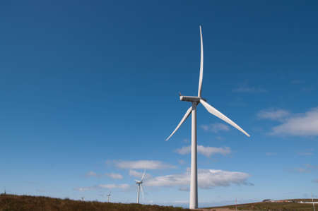 A row of wind turbines on a wind farm in Scotland, Europe.
