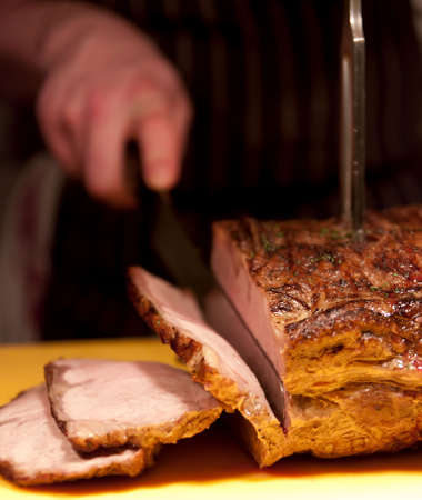 Succulent roast pork carved in a restaurant. Shallow focus on foreground.の写真素材