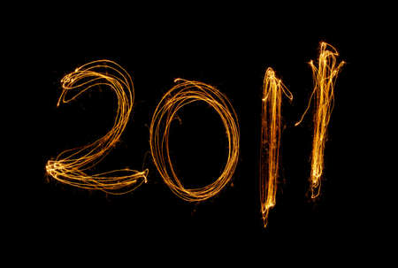 New Year celebration sparklers writing 2011 against black background.の写真素材