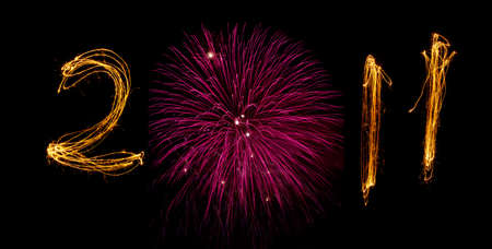 Celebration sparklers writing 2011 against black background. Zero replaced by circular pink fireworks display.の写真素材