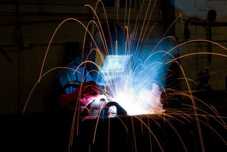 Arc welding in manufacturing plant with flying sparks