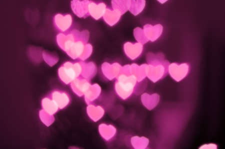 Heart-shaped lights out of focus against dark backgroundの写真素材