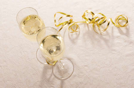 Two filled champagne glasses from above with gold ribbon framing much copy space の写真素材