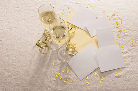 Two filled champagne glasses from above with gold ribbon and blank spaces for photos and text