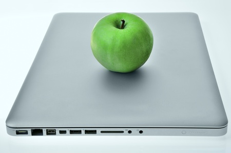 Laptop with green apple on the cover.の写真素材