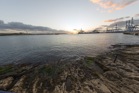 Sunrise view of Marsaxlokk Harbor, from Birzebbuga, with power station on the left and Malta Freeport on the rightのeditorial素材