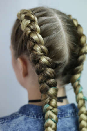two thick braids with a kanekalon on light hair, a youth hairsty