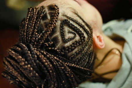 thin braids on the head with drawings, African or ethnic styleの写真素材