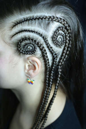 a pattern of braids on the temple, a shaved temple, creative shaving, an art barber, spirals of...