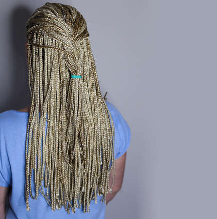 many african thin braids braided on the head of a blond girl, on