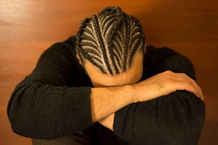 small braids on his head Man with face covered, dark hair, Schot