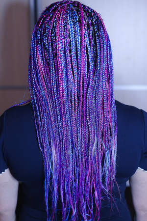 a lot of thin African plaits with artificial material, blond close-up on a light background, beauty...
