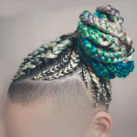 cornrows women A woman with a haircut on a white background, tight braids braided into a tail, artificial material woven into her hairの写真素材