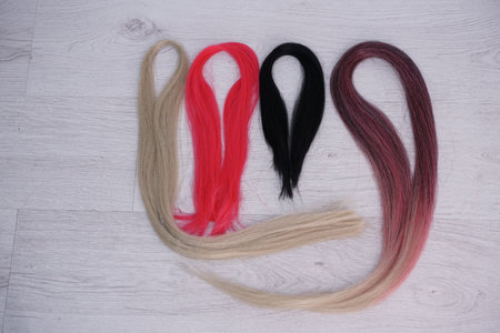 Artificial material for weaving African braids, colored kanekalon lies on the table, different...