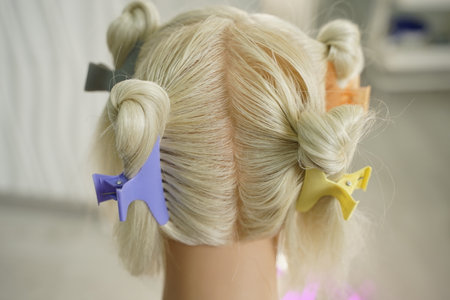 marking a mannequins head into zones, hairdressing, teaching students, hair cutting, braiding. The master demonstrates to his students the division of the head into zonesの写真素材