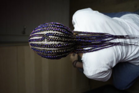 The master demonstrates to students how to weave an African braid with Kanekalon on a model, afro-locks on a frame, frame hairstyles, afro-curls, a base for hair extensions, a thin braid braided over a girl head, Senegalese braids on a frameの写真素材