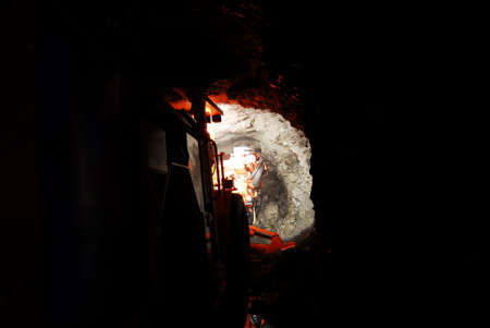 heavy duty mine machine working inside a dark mine shaft