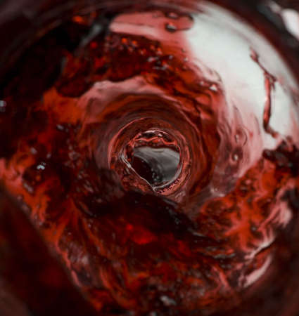 Wine pouring in a glass captured from unusual POV inside the bottle stock photoの写真素材