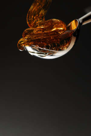 Honey being poured into a spoon の写真素材